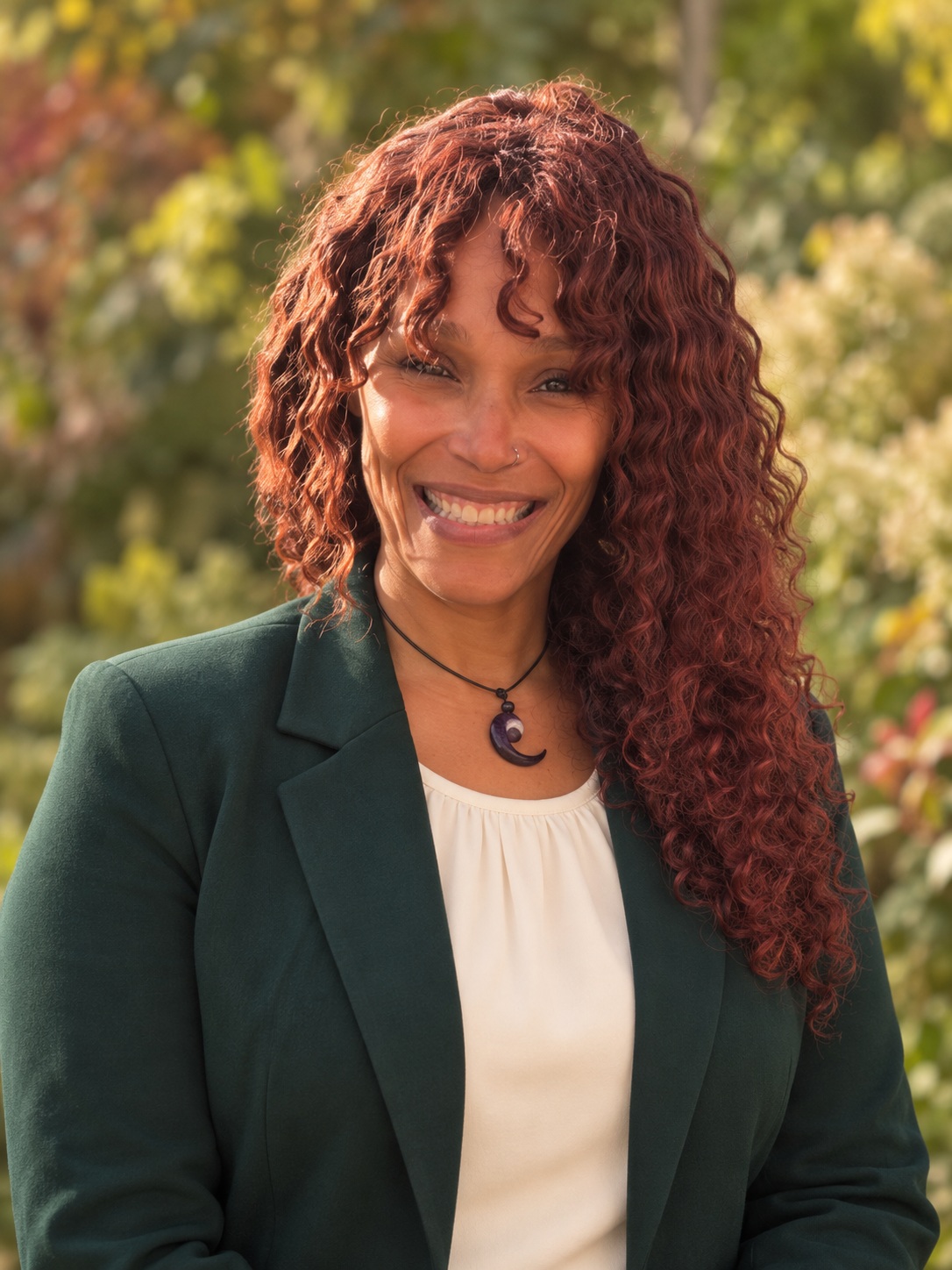 Dr. Nicki Pascetti smiling, wearing a forest-green blazer